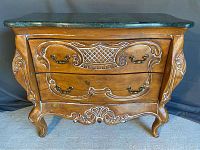 Front view of the dresser showing the wood finish, curved front, carved details, and green marble top.
