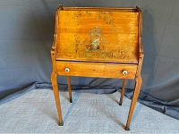 Front view of closed drop-front secretary desk showing porcelain knobs on lower drawer