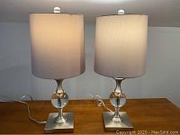 Front view of both lamps side by side on wooden surface