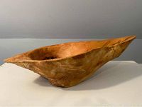 Side view showing bowl’s elongated organic form and exterior grain patterns
