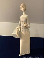 Full view of the Lladro porcelain figurine showing full body and the basket she is holding.