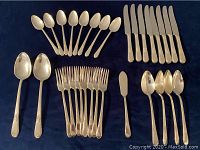 Complete set of 32 pieces laid out on dark blue cloth for clear view of all items included in lot.