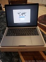 Front view of MacBook Pro open on welcome setup screen