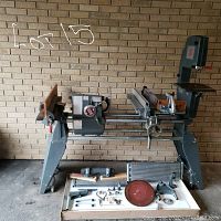 Full view of Shopsmith Mark V with sliding table, rails and assortment of attachments laid out on floor.