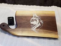 Front view of walnut cutting board with cat face inlay design