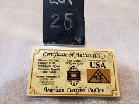 Certificate of authenticity showing 24 karat gold, 1 grain weight, 99.99% fineness, and bar dimensions.