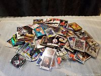 Wide view of the lot showing a large number of NHL hockey cards scattered on a surface, some in protective plastic sleeves and cases, displaying various players and team logos.