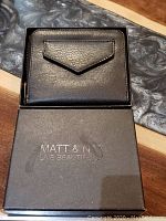Closed Matt & Nat wallet inside branded box showing front flap pocket.