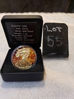 Obverse side showing eagle and nuclear explosion design with gold finish and coin details in case.