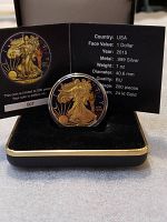 Front view of 2015 Liberty Silver Dollar coin with 24k gold finish showing Lady Liberty design and certificate card.