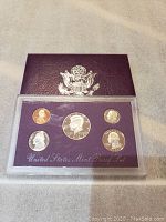 Front view of 1991 S Mint Proof Set coins showing obverse side of Lincoln cent, Jefferson nickel, Roosevelt dime, Kennedy half dollar, and Washington quarter.