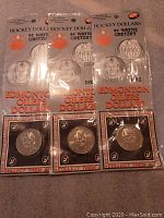 Three sealed 1983 Wayne Gretzky Edmonton Oilers Hockey Dollar coins with embossed portrait and original packaging.