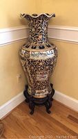 Full view of 37-inch Asian floor vase on wooden stand, showing fluted rim and ornate gold and dark blue decoration.