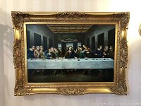 Full view of rectangular painting in ornate gold frame depicting Last Supper at a long table under coffered ceiling