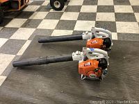Two Stihl leaf blowers side by side on checkered floor