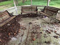 Three benches arranged in a gazebo setting, showing overall grouping and surrounding leaf debris