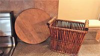 Photo of the round solid wood Lazy Susan leaning against the wall and the bamboo wine basket sitting on the counter.