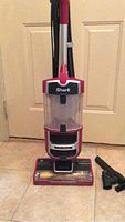 Front view of Shark Lift-Away upright vacuum showing the clear dustbin, red and black design, and vacuum base.