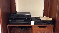 Three Sony electronic components stacked on a wooden shelf, including a 5 disc CD player, VCR and stereo cassette deck.