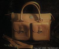 Front view of light brown leather handbag with two front buckle pockets and top handles, along with detachable shoulder strap beside it