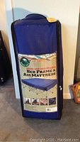 Full view of boxed Ozark Trail queen size collapsible bed frame and air mattress in navy blue carrying case.