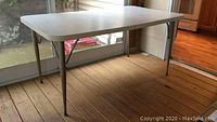 Full view of the retro rectangular Formica table with metal legs, showing its structure and legs.