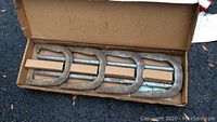 Horseshoes game set consisting of four heavy metal horseshoes in original cardboard box showing condition and contents