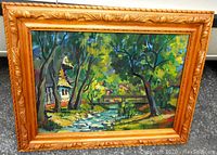 Wide front view of framed painting resting on ground