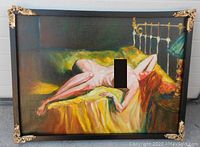 Front view of the oil painting showing a nude woman reclining on a yellow bed with gold decorative corners on the ebony wood frame.