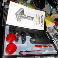 Open case showing boxed microscope set with microscope body, tools, jars, slides and instruction manual inside plastic tray