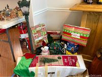 Image showing boxed 7 ft tree, snowman figure, garland, and lighted street post alongside various holiday items