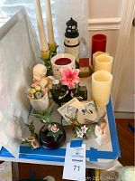 Full overview of assorted decorative items including lighthouse light, candlesticks, floral salt and pepper holder, ceramic flowers nightlight, and figurines.