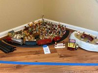 Wide view of miniatures on train track, train with several cars, and ice skating rink