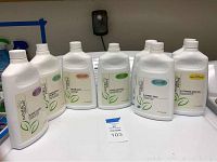 Seven bottles of Natural Visions highly concentrated cleaning products on a white table, showing front labels clearly.