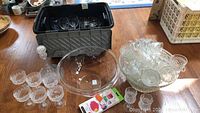 Overview showing large punch bowl with pedestal base, multiple punch cups arranged, plastic bowl, and stacked glasses in container