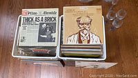 Two large storage bins filled with vinyl LP records, showing Jethro Tull 'Thick As A Brick' and a Dvorak classical record on top.