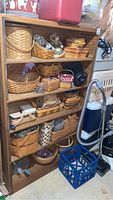 Front view of wooden bookcase filled with various woven baskets and household items showing overall condition and item presentation.