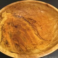 Top view showing the bowl's curved interior, natural wood grain, and live-edge design with distinctive dark streaks and knots.