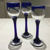 Front view of three Robert Held signed glass goblets with clear and blue glass and twisted stems