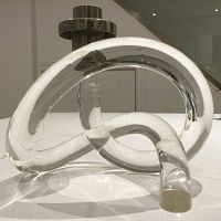 Front view of the candlestick holder showing pretzel-shaped lucite base and gold-tone metal candle cup