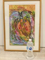 Frontal full view of framed serigraph artwork with water bottle for size reference on floor.