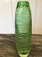 Front view of tall green glass vase showing spiral incised decorative lines