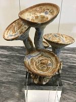 Front view of vintage stoneware flower sculpture with visible floral shapes and glaze