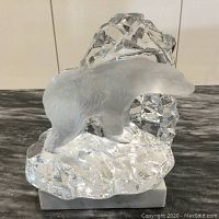 Front view of Nybro Sweden crystal polar bear sculpture showing frosted bear on clear faceted icy base on marble platform.
