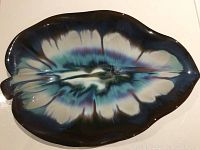 Top view of the large vintage artisan pottery tray showing the multicolored glaze pattern resembling organic leaves or waves with blue, teal, white and brown dripping glaze finish.