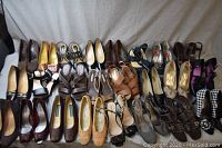 Full view of 24 pairs of women's shoes laid out on a surface showing various colors and styles.