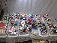 Wide view of all bins arranged on table showing assortment of thread, buttons, and storage bins
