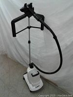 Full view of Conair clothes steamer system displaying white wheeled base with vertical stand and steam hose extending upward.