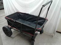 Front-side view of the large folding collapsible canvas utility cart on wheels, showing overall size and design with handle extended.