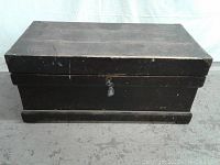 Closed old wooden carpenter's tool box with visible metal lock and skeleton key inserted.